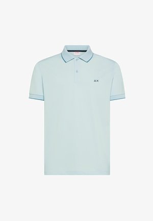 Polo de manga corta de color azul claro con dos botones, ribetes contrastantes en el cuello y las mangas, y pequeño logo negro en el pecho izquierdo.