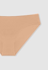 Brief in cotone beige con una texture liscia, design a vita alta e senza cuciture visibili, caratterizzato da un taglio classico e uno stile minimalista.