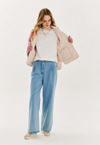 Prešívaná ružová bunda, bielo tričko, svetlo modré široké džínsy a béžové tenisky. Bunda má vzorované rukávy a prednú kapsu.