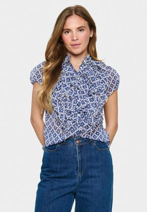 Blauwe blouse met patroon, ruches en korte mouwen, voorzien van een knoopsluiting en een delicate textuur, gecombineerd met high-waisted spijkerbroeken.