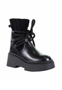 Czarne skórzane botki za kostkę z grubą platformą, z miękkim czarnym mankietem z tkaniny oraz teksturowanymi czarnymi sznurowadłami. Srebrne akcenty z metalu.