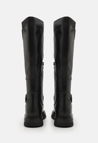 Botas de cuero negras hasta la rodilla con una textura suave, punta redonda y cremalleras laterales; cuentan con una suela plana y texturizada y un diseño con costuras mínimas.