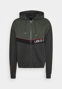 Mikina s kapucí a zipem v tmavě šedé barvě s horní částí se zeleným vzorem, obsahující logo "CARLO COLUCCI" v bílé a červené barvě. Měkký textilní materiál z bavlněné směsi.