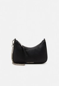 Μαύρη ψεύτικη δερμάτινη τσάντα με καμπυλωτό σχήμα, ασημένια αλυσίδα ιμάντα, κλείσιμο με φερμουάρ και ανάγλυφο όνομα μάρκας στο μπροστινό μέρος.