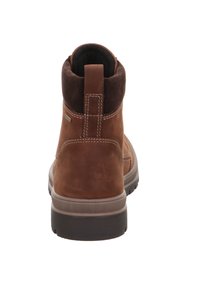 Hnědá kožená kotníková bota s nubukovým límcem, bílými švy a texturovanou gumovou podrážkou. Obsahuje zadní poutko.