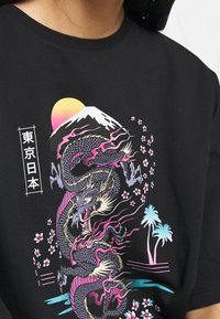 Černé bavlněné tričko s živou grafickou ilustrací draka, hory Fudži, slunce a třešňových květů v růžových a modrých odstínech.