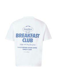 Hvid bomulds T-shirt med en stor blå grafisk tekst på ryggen, der står "BREAKFAST CLUB" og yderligere oplysninger om en kaffebedrift.