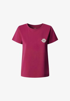 Magenta pamukasta majica s kratkim rukavima i okruglim izrezom; sadrži mali bijeli otisak usana s tekstom na prsima.