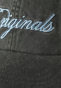 Sort denim baseball cap med broderet "originals" tekst i lys blå. Teksturen er glat med en struktureret skygge og syninger.
