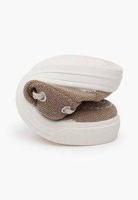 Beige Leinenschuhe mit einer strukturierten Oberseite, weißer Gummisohle und Ösen für die Schnürsenkel. Die Schuhe sind in der Mitte gefaltet dargestellt.