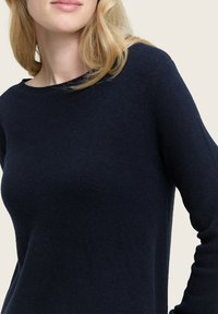 Marineblauer Strickpullover mit Rundhalsausschnitt und langen Ärmeln, der über eine weiche Textur und eine lockere Passform verfügt. Keine sichtbaren Muster oder Beschläge.
