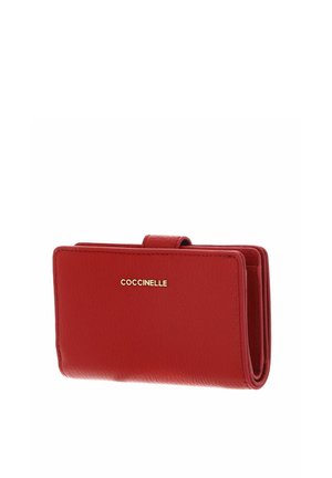 Portafoglio in pelle rossa pieghevole con logo dorato "Coccinelle" e chiusura a scatto, mostrato su sfondo bianco.