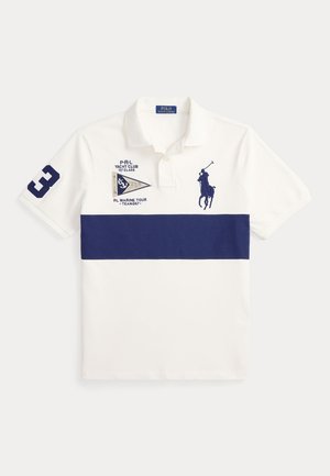 Polo blanc avec une bande horizontale bleu marine, logo d’un joueur de polo bleu marine sur la poitrine, numéro 3 sur la manche, et texte et emblème du yacht club à l’avant.