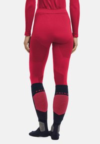 Rote thermische Leggings mit strukturierten Einsatz und figurbetontem Design. Mit dunkelblauen und grauen Akzenten an den Knöcheln sowie "FALKE"-Markierung.