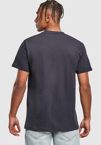 Mørkeblå t-shirt med korte ærmer og rund udskæring, lavet af bomuld, med en glat tekstur og lige kant.