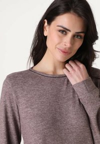 Maglietta a maniche lunghe in tessuto marrone melange, con scollatura rotonda e vestibilità comoda. Tessuto liscio con dettagli di cucitura sottili.