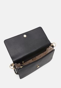 Czarna skórzana torebka o gładkiej fakturze, z klamrą na złoty zatrzask i wewnętrzną kieszenią z wzorem monogramu.