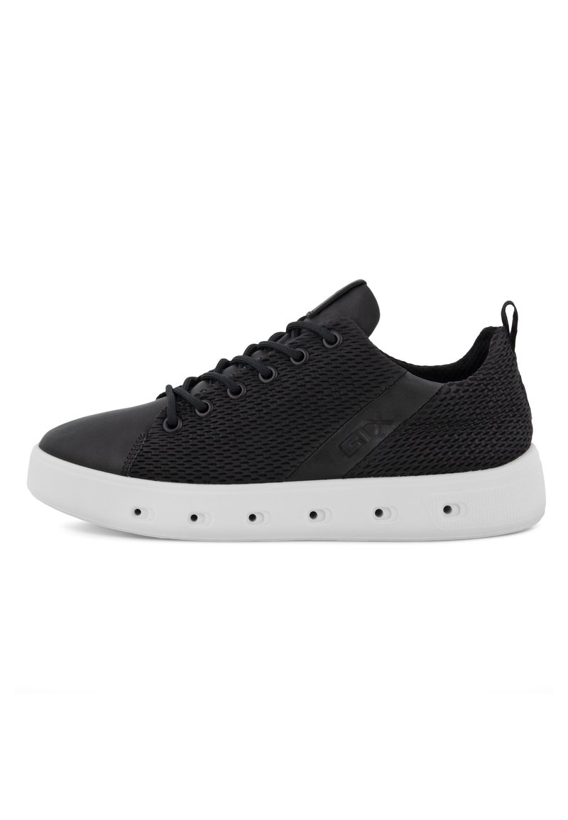 Czarne siateczkowe sneakersy z sznurówkami, wyściełanym kołnierzem, pętlą na pięcie oraz białą grubą podeszwą z okrągłymi otworami wentylacyjnymi.