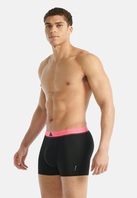 Czarne bokserki z różową, elastyczną talią, na której znajduje się teksturowany wzór i logo, dopasowane, o gładkim wykończeniu.
