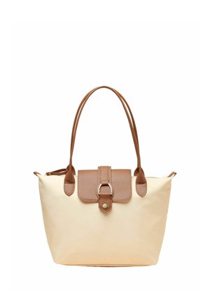 Beżowa torba typu tote z brązowymi skórzanymi uchwytami i klapą zapięcia z metalowym pierścieniem i guzikiem.