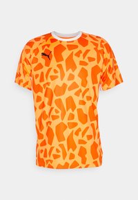 Camiseta naranja con un diseño de patrón de jirafa con formas variadas. Hecha de tela ligera; tiene un cuello redondo blanco y un logo negro.