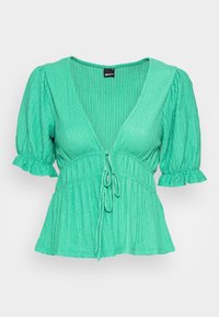 Blusa de manga curta verde menta com decote em V, cintura com cordão, textura canelada e bordas de mangas com frufrus. Design casual.