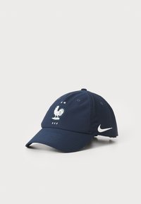 Casquette bleu marine arborant un emblème de coq et trois étoiles, fabriquée en tissu à la texture lisse, dotée d'un bord incurvé et du logo Nike.