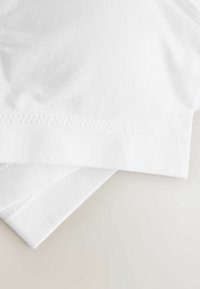 Vitt bomullstyg med en slät textur, med ribbade kanter och ett lager på lager-arrangemang. Inga synliga mönster eller detaljer.