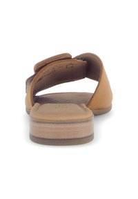Sandal in pelle marrone con retro aperto, fascia larga e suola piatta in gomma. Il dettaglio della soletta testurizzata è visibile.