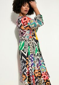 Kimono multicolore con vari motivi tra cui stampa animale, design geometrici e accenti vivaci; tessuto leggero e fluido.