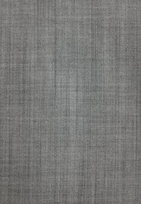 Gros plan d’un tissu gris tissé serré avec un motif discret en grille et de petits fils espacés régulièrement.
