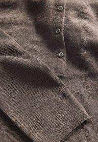 Smešani smeđi pleteni pulover s dugim rukavima i gumbima, s četiri tamna gumba, položen ravno s vidljivom teksturom.