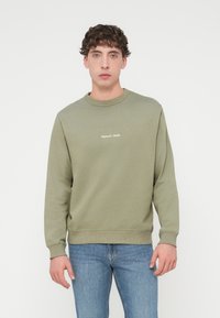 Φωτεινό πράσινο φούτερ με στρογγυλή λαιμόκοψη από απαλό ύφασμα, με ριμπ μανσέτες και τελείωμα, με κεντημένο το "Original Attitude" στο μπροστινό μέρος.