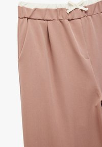 Helle rosa, glatte Jogginghosen mit elastischem Bund, Detail mit Kordelzug und Seitentaschen. Moderner, taillierter Schnitt.