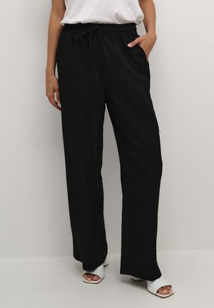 Pantaloni neri a gamba larga con vita elastica e cordoncino. Realizzati in un tessuto testurizzato, presentano tasche laterali e una vestibilità comoda.