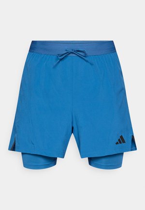 Siniset urheilushortsit, joissa on joustava vyötärönauha, kiristysnaru, sivuhalkiot ja yksivärinen muotoilu. Lahkeessa musta logotunnus.