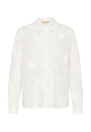 Balta krekla ar pogām izgatavota no viegla auduma, ar teksturālu ziedu izšuvumu un klasisku apkakli. Garas piedurknes ar pogāmiem aprocēm.