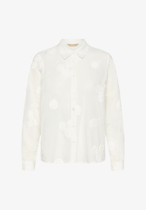 Balta krekla ar pogām izgatavota no viegla auduma, ar teksturālu ziedu izšuvumu un klasisku apkakli. Garas piedurknes ar pogāmiem aprocēm.