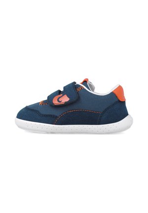 Zapatilla deportiva azul marino con un upper de tela texturizada, acentos naranjas y una correa de gancho y bucle. Suela de goma blanca con pequeñas perforaciones.