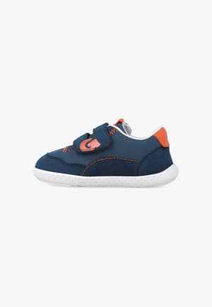Zapatilla deportiva azul marino con un upper de tela texturizada, acentos naranjas y una correa de gancho y bucle. Suela de goma blanca con pequeñas perforaciones.