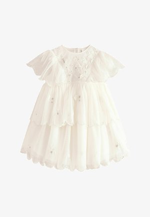 Bílé šaty s rozšířenými rukávy, vrstvenými volány a vlnkovaným lemem. Obsahují květinovou výšivku na korzetu a průhlednou texturu.