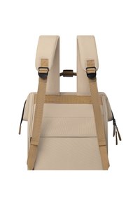 Sac à dos beige avec des bretelles rembourrées et réglables, une poignée supérieure et une texture lisse. Il dispose d'une poche zippée et d'un matériel minimal.