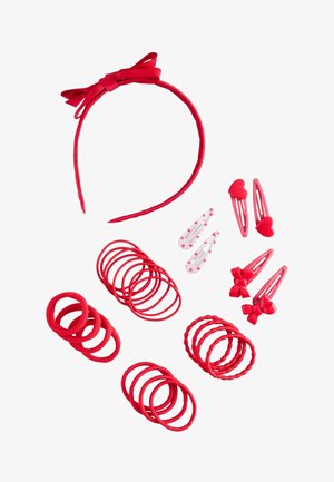 Rote Haaraccessoires, darunter ein Haarband mit Schleife, Paare von Clips mit Herzen und Schleifen sowie mehrere runde Haargummis in verschiedenen Schattierungen und Texturen.