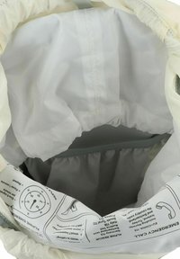 Trekkoord tas met een lichtbeige buitenkant en grijze voering. Voordat gedrukt op de binnenkant staan noodinstructies. Soepele textuur.