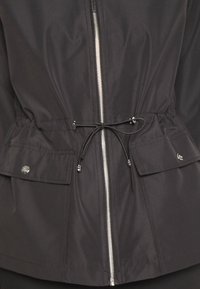 Czarna lekka kurtka z zamkiem błyskawicznym z przodu, ściągaczem w talii i dwoma bocznymi kieszeniami. Wykonana z gładkiej tkaniny o matowym wykończeniu.