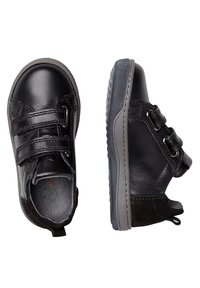 Scarpe in pelle nera con cinturini in Velcro, suole in gomma e punta arrotondata. La vista laterale mostra un esterno testurizzato e dettagli grigi.