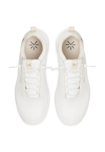 Bílé sportovní boty s texturovaným textilním svrškem, elastickým šněrovacím systémem, polstrovaným límcem a logem vytištěným na stélkách.