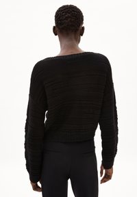 Black knitted sweater with a cropped design, featuring textured horizontal stripes and wide sleeves. Ribbed hem at the waist.