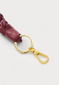 Braided burgundy leather keychain with a gold metal ring and lobster clasp, featuring a textured finish and engraved branding.