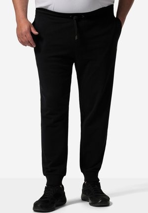 Sorte sweatpants lavet af et blødt, strækbart stof. Har en elastisk talje med snor og ribbede manchetter ved anklerne.